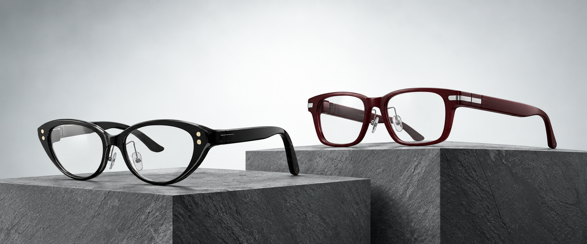 Hearview Lite black Cat-eye and red Classic subtitle glasses on gray stone blocks